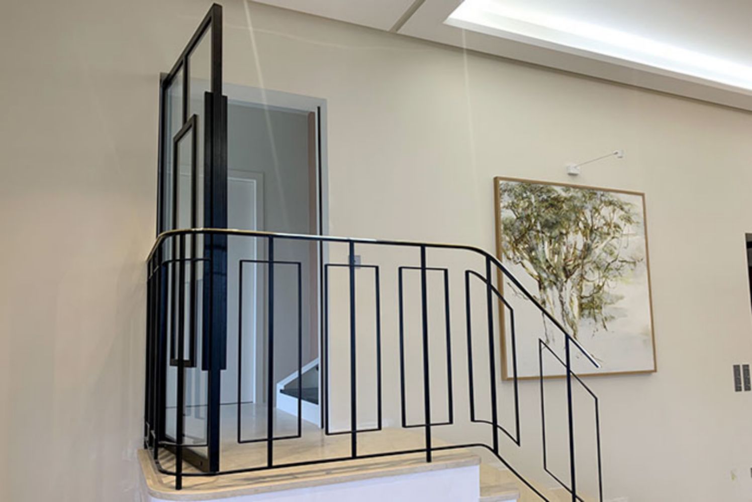 porte_ouverte_interieur_sur_pivot_avec_rampe_d_escalier_main_courante_laiton_poli_ct_metal_concept.jpg